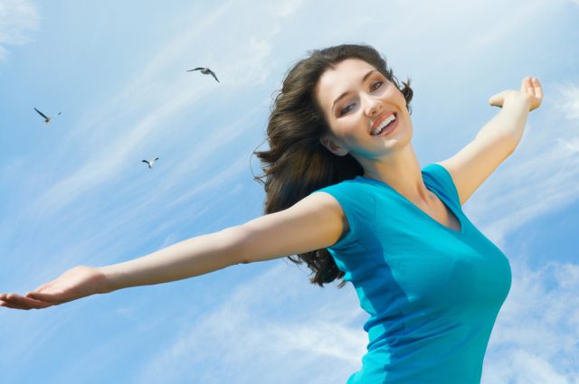 woman walking on the beach with a happy smile on her face