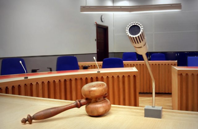photo of a court room from the judge's bench showing a gavel, microphone and the jury seats in the distance