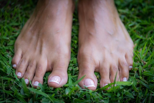 Earthing or grounding, woman without shoes standing on the ground, feeling the grounded.