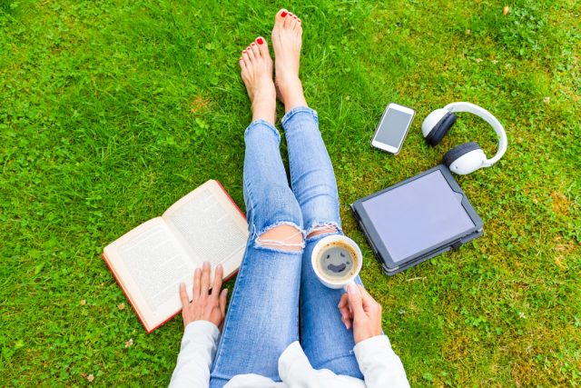 woman sitting on the ground bare foot touching the earth showing earthing and grounding herself to the earth