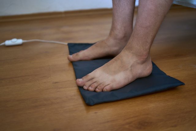 the man put his feet on the grounding wedge, self-soothing, relaxation and grounding to the earths energy